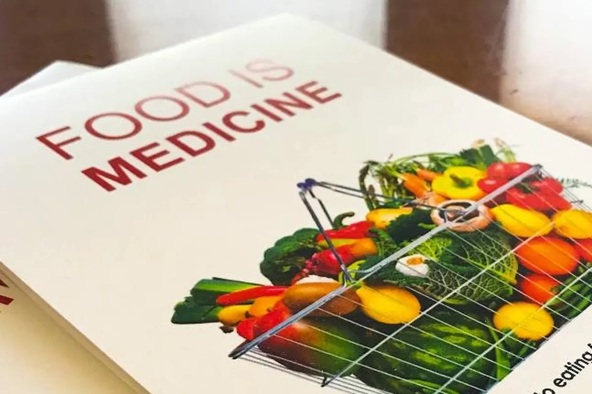 A Food Is Medicine guide with a basket of colorful fresh vegetables