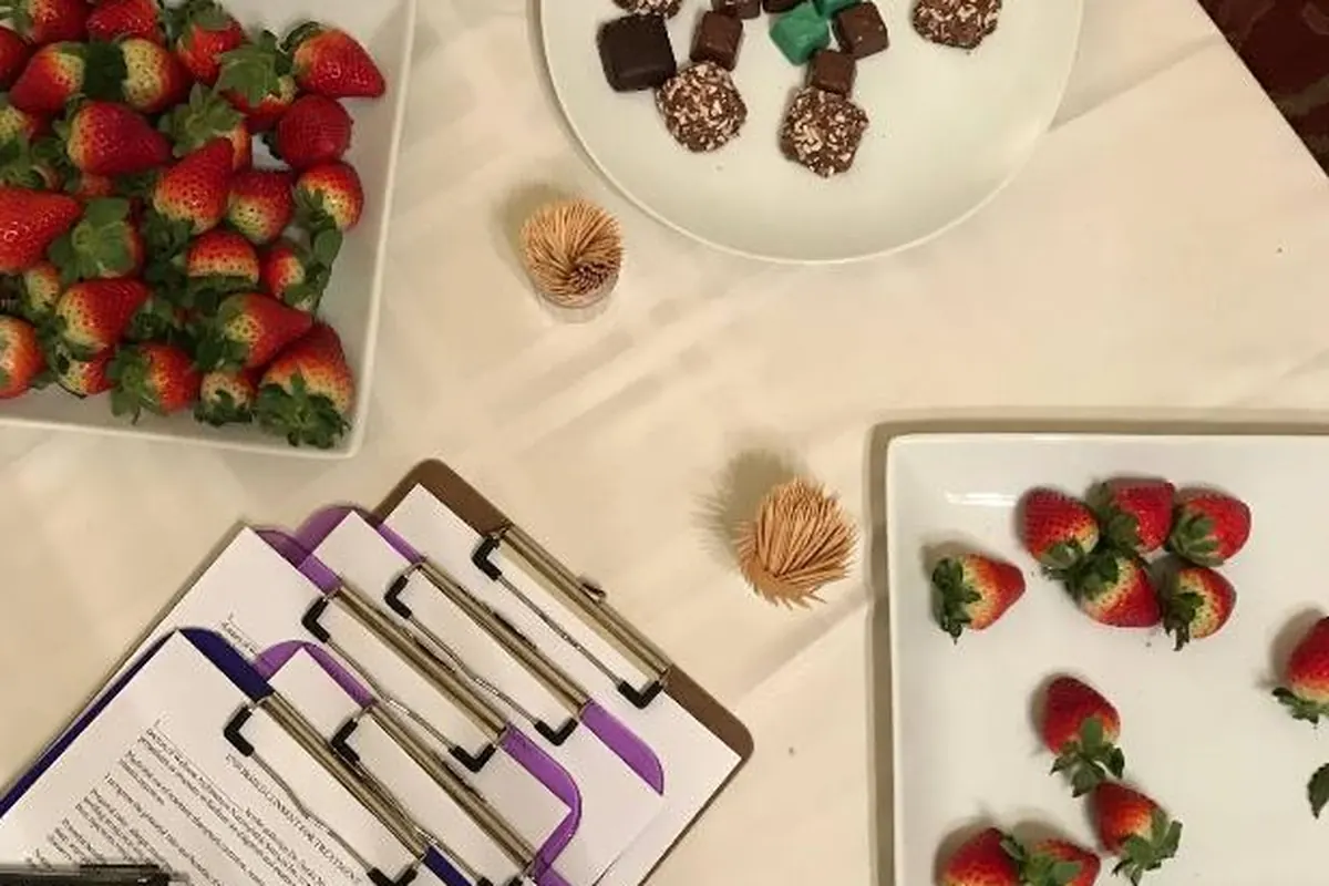 A table of fresh strawberries and wholesome foods beside patient intake clipboards