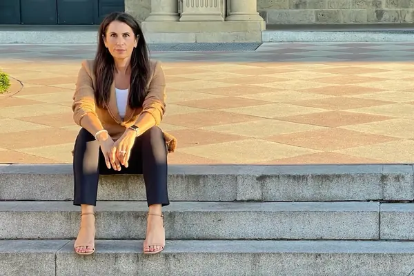 Dr. Samia McCully, ND seated on sunlit stone steps